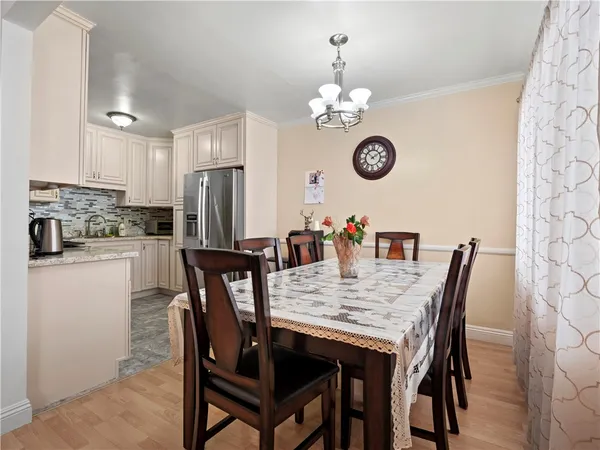 a view of a dining room with furniture a chandelier and wooden floor