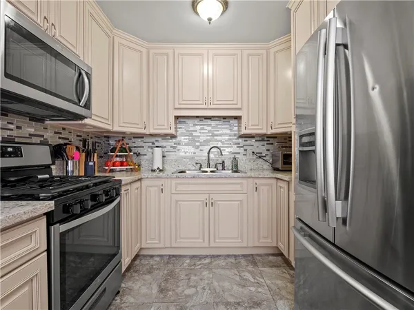 a kitchen with stainless steel appliances granite countertop a refrigerator sink and stove