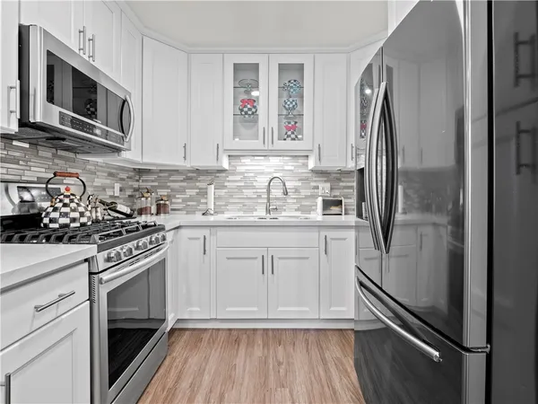 a kitchen with stainless steel appliances a refrigerator sink and microwave