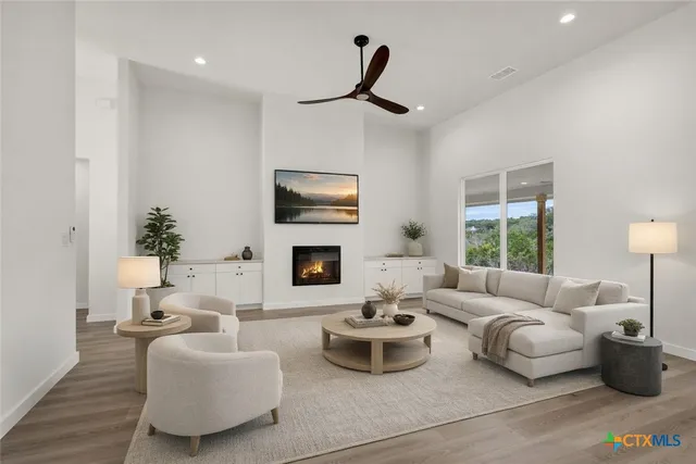 a kitchen with stainless steel appliances granite countertop a sink a stove a dining table and chairs with wooden floor