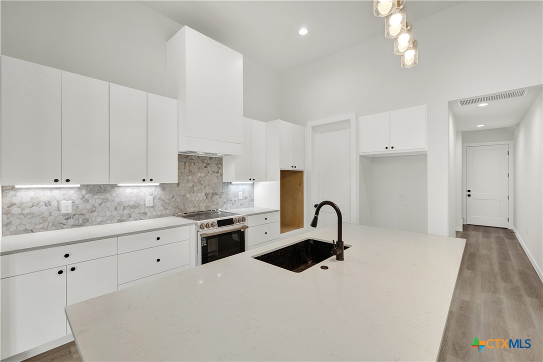 328 Compass Rose Spring Branch, TX 78070 - Photo 15 of 48 a kitchen with granite countertop a sink stainless steel appliances and white cabinets