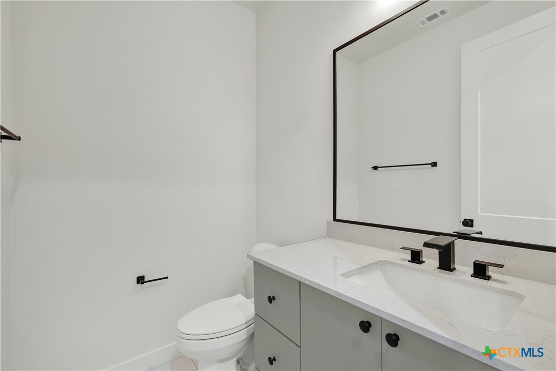 328 Compass Rose Spring Branch, TX 78070 - Photo 23 of 48 a bathroom with a granite countertop sink a toilet and a mirror