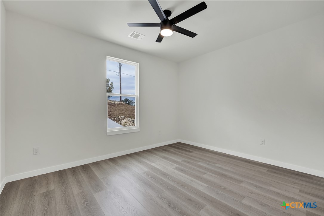 328 Compass Rose Spring Branch, TX 78070 - Photo 33 of 48 an empty room with wooden floor and ceiling fan