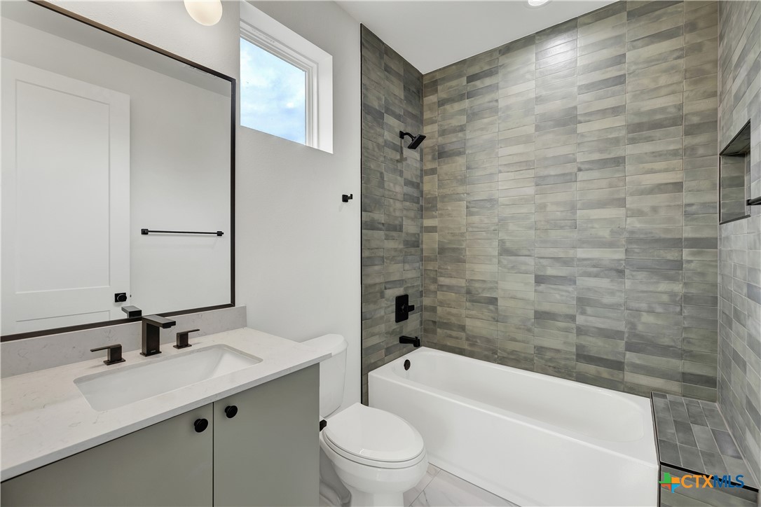 328 Compass Rose Spring Branch, TX 78070 - Photo 34 of 48 a bathroom with a bathtub shower sink mirror vanity and toilet