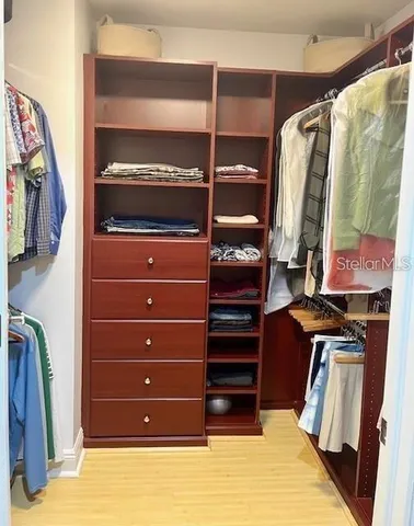a view of walk in closet with clothes and shoes