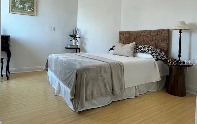 a bedroom with a bed and wooden floor
