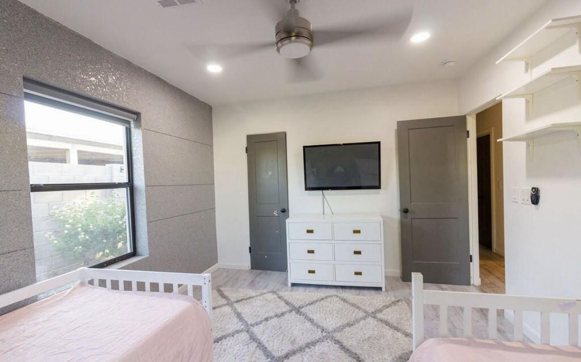 4214 North 20th Street Phoenix, AZ 85016 - Photo 15 of 40 a spacious bedroom with a bed and a flat screen tv