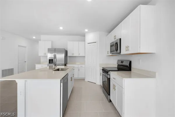 a kitchen with stainless steel appliances a sink stove top oven and cabinets