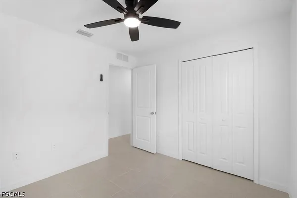 an empty room with a ceiling fan and a shower