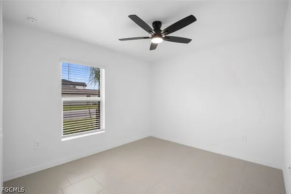 an empty room with a window and a fan