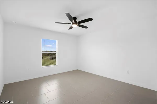 an empty room with a window and a fan