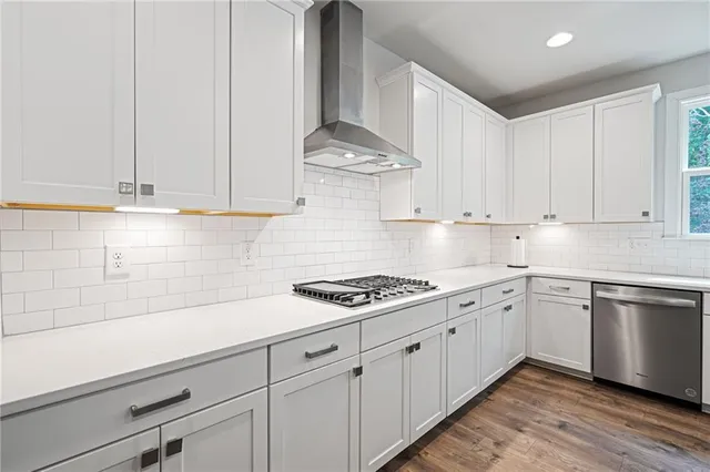 a kitchen with stainless steel appliances white cabinets and a stove
