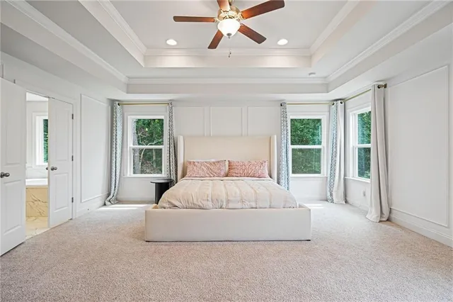 a spacious bedroom with a large bed and a chandelier