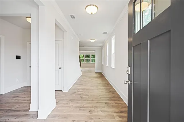 a view of a hallway with wooden floor and staircase
