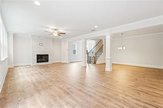 a view of an empty room with wooden floor and a fireplace