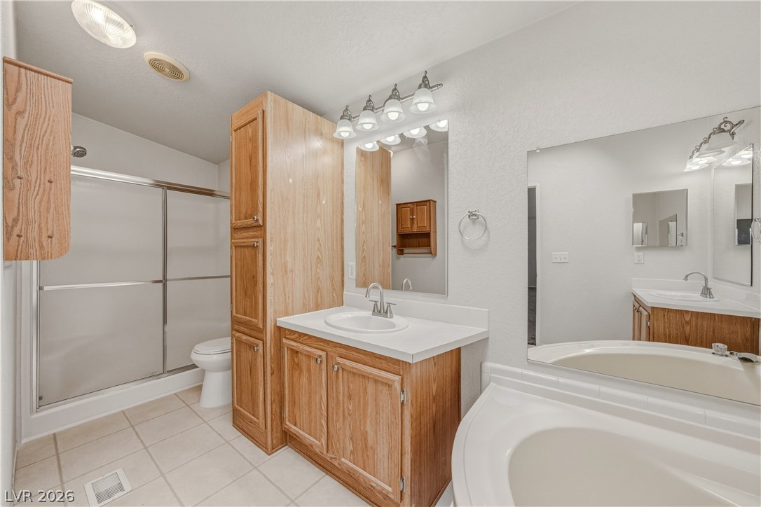 1890 West Dyer Road Pahrump, NV 89048 - Photo 25 of 40 This bathroom features a shower, a vanity with a sink, and a separate tub.