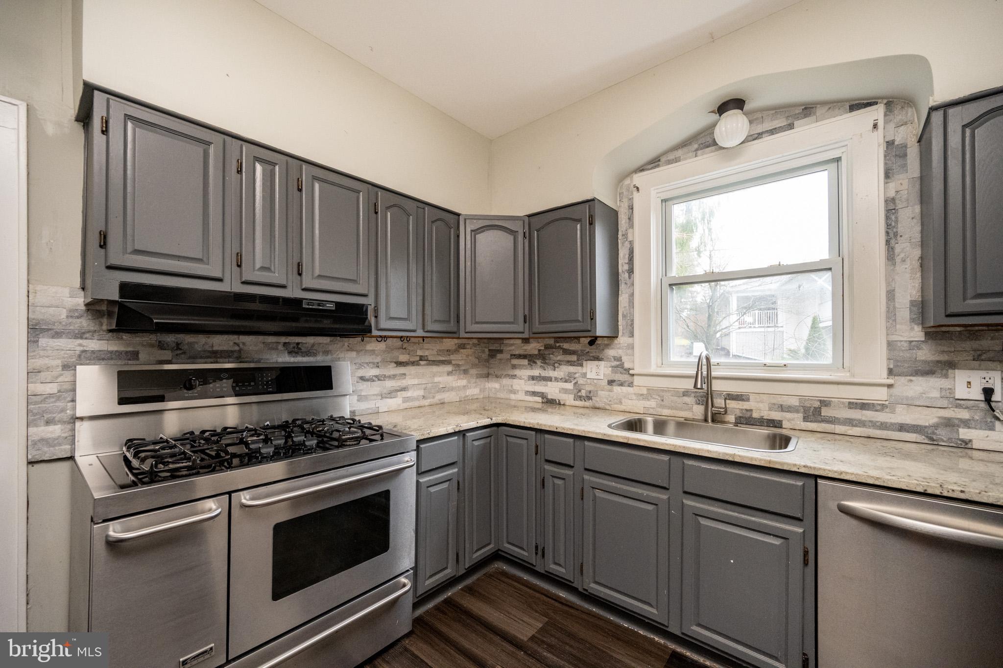 449 South 3rd Street Oakland, MD 21550 - Photo 5 of 64 a kitchen with granite countertop a sink cabinets stainless steel appliances and a window