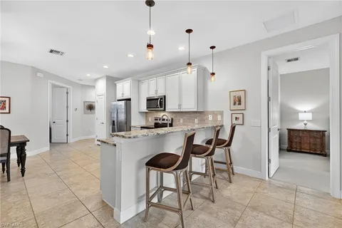 a open kitchen with stainless steel appliances granite countertop a refrigerator and a stove top oven