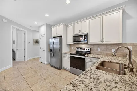 a kitchen with stainless steel appliances granite countertop a refrigerator a stove a sink and a microwave