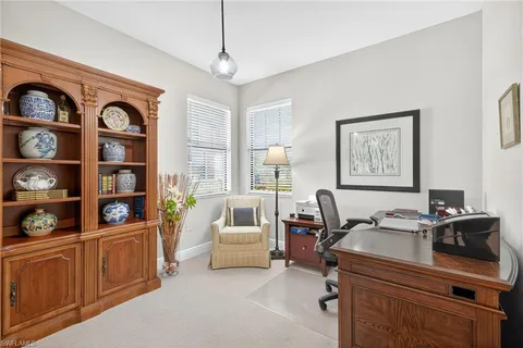 a view of a workspace with furniture and a window