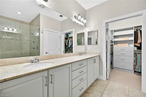 a bathroom with a granite countertop sink double vanity and a mirror