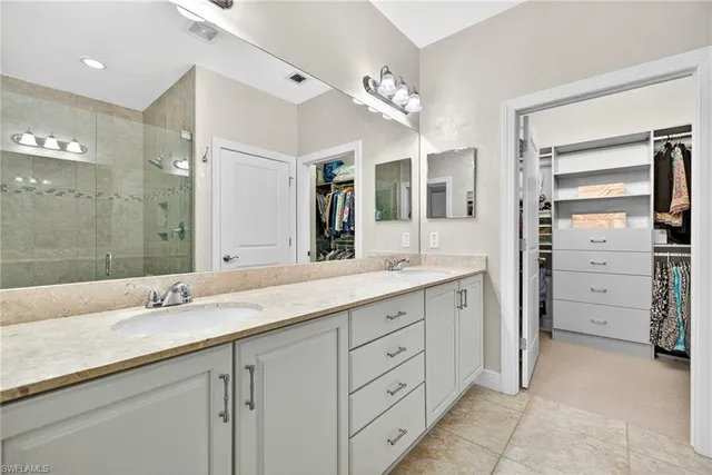 a bathroom with a granite countertop sink double vanity and a mirror