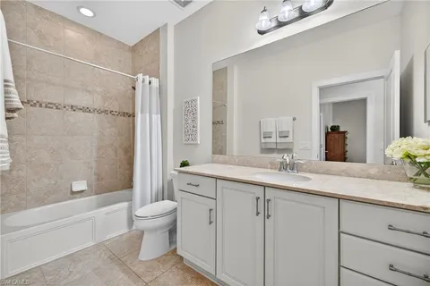 a bathroom with a granite countertop sink a toilet and a bathtub