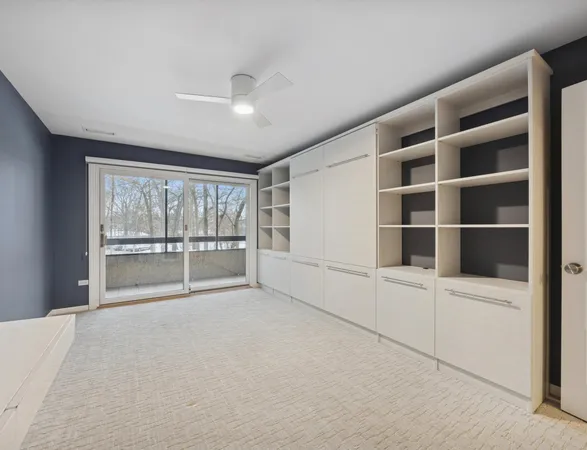 a view of an empty room with a window and cabinet