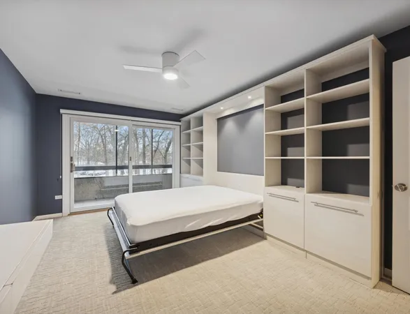 a bed sitting in a bedroom next to a large window