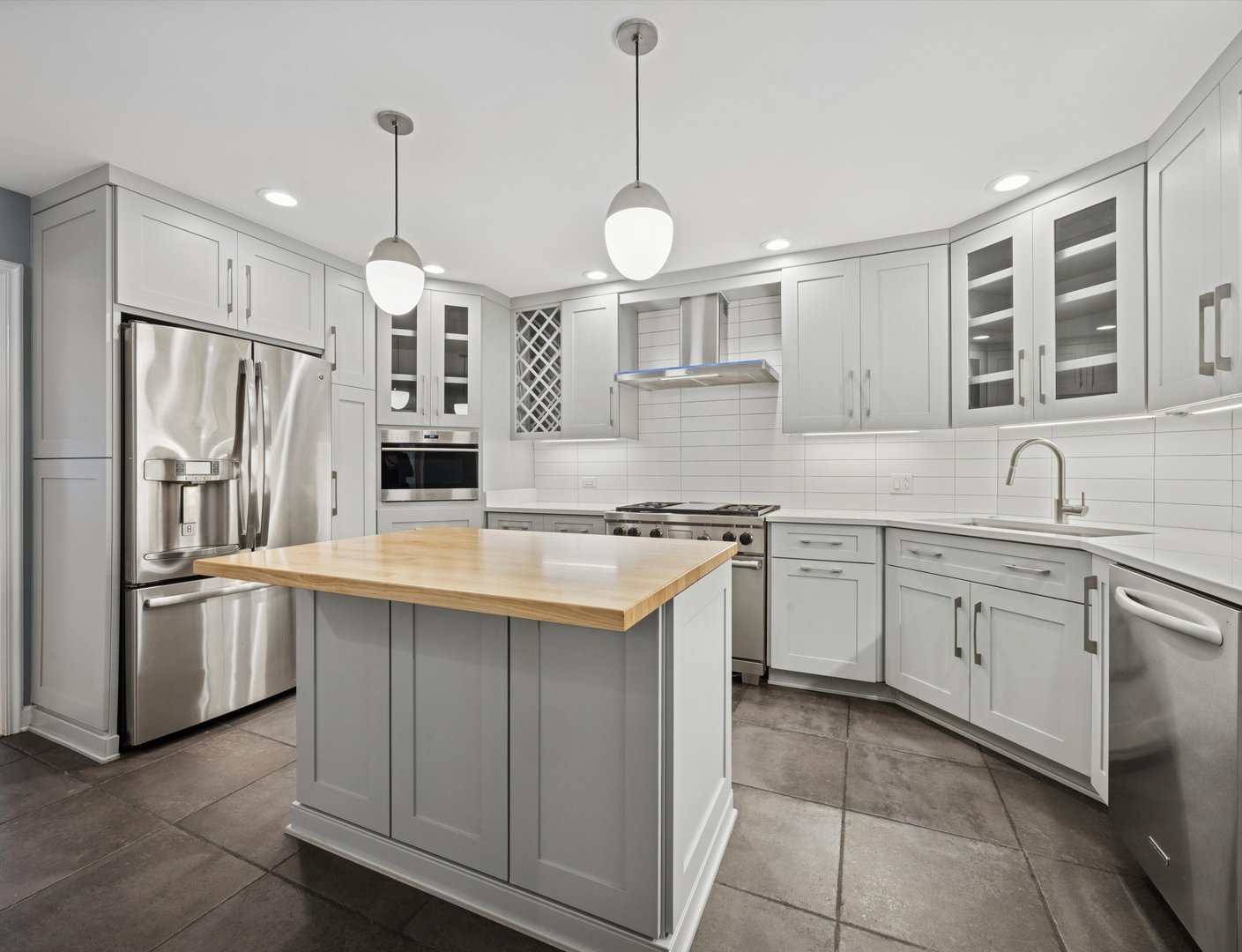 1401 Burr Oak Road, Unit 105B Hinsdale, IL 60521 - Photo 5 of 27 a kitchen with stainless steel appliances granite countertop a sink a stove a refrigerator and island with wooden floor