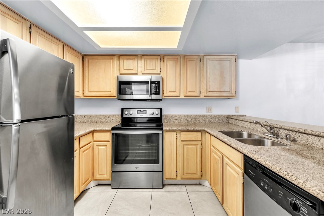 6250 West Flamingo Road, Unit 98 Las Vegas, NV 89103 - Photo 8 of 40 Kitchen with light brown cabinets, light tile patterned floors, a sink, and stainless steel appliances
