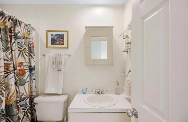 a bathroom with a sink toilet and a mirror
