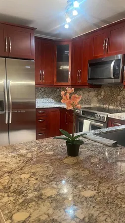 a kitchen with stainless steel appliances granite countertop a sink and a stove