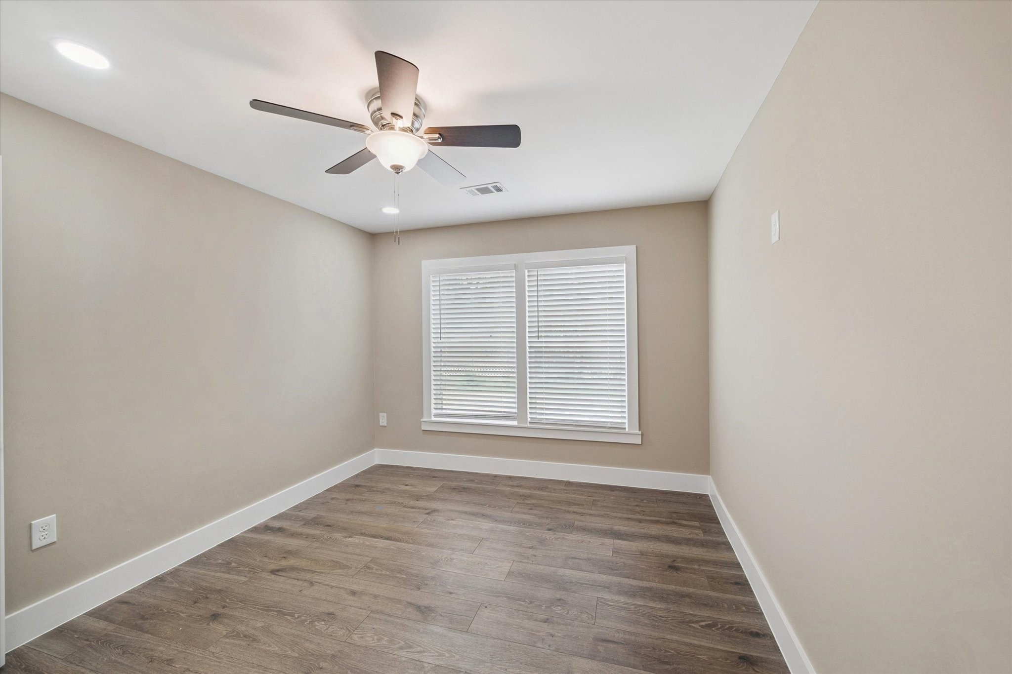 7229 Touchstone Street Houston, TX 77028 - Photo 8 of 11 an empty room with wooden floor fan and windows