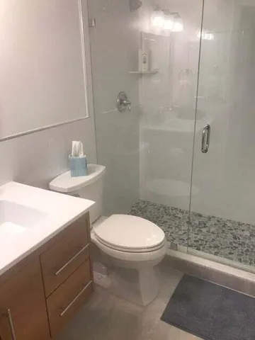 a bathroom with a sink a toilet and shower