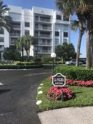a front view of building with garden and flowers