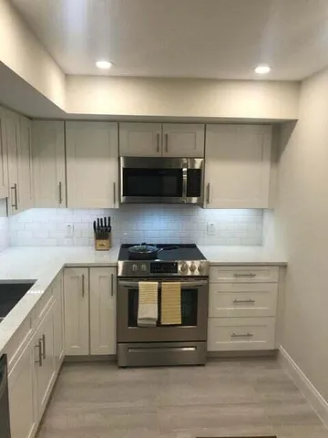 a kitchen with stainless steel appliances granite countertop a stove and a sink