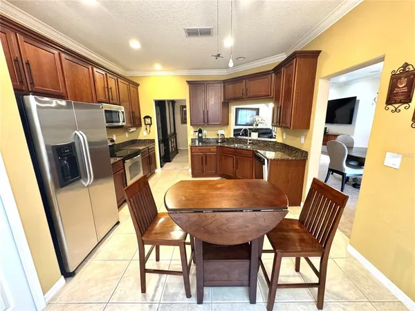 a kitchen with stainless steel appliances granite countertop sink stove refrigerator and microwave