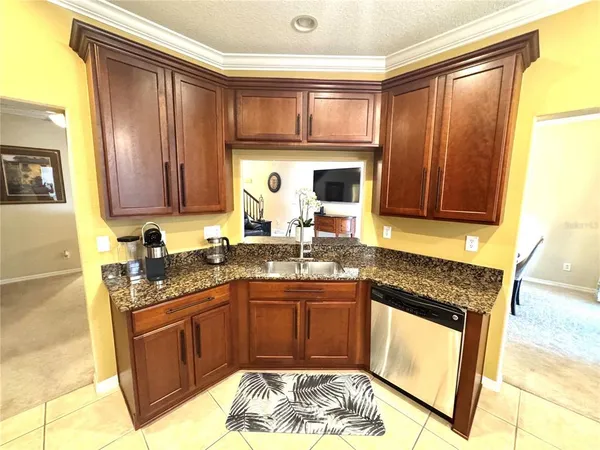 a kitchen with stainless steel appliances granite countertop a stove top oven a sink a dining table and chairs with wooden floor