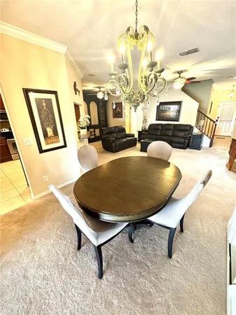 a view of a dining room with furniture and a chandelier