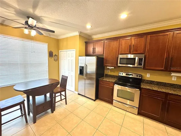 a kitchen with stainless steel appliances a stove a sink a microwave a refrigerator and cabinets