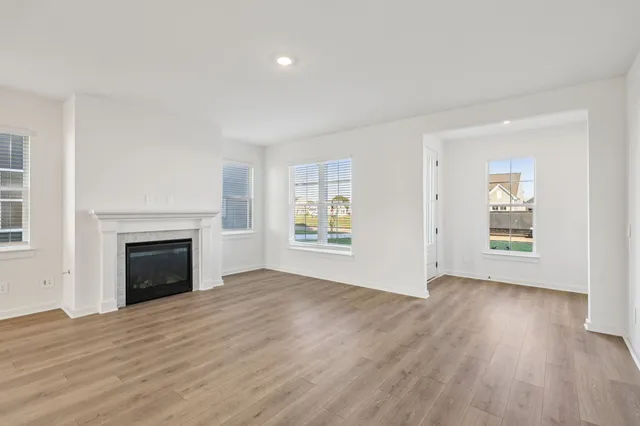 an empty room with windows and fireplace