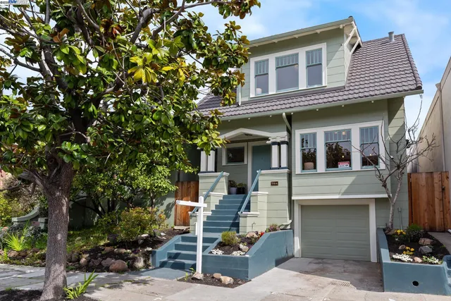 a view of a white house with large windows and a tree