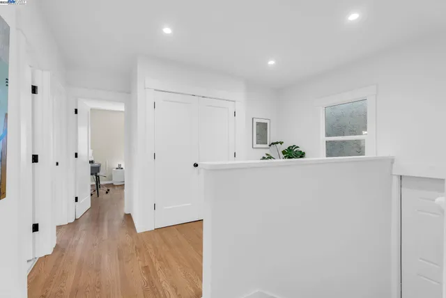 a view of a hallway with wooden floor and cabinet