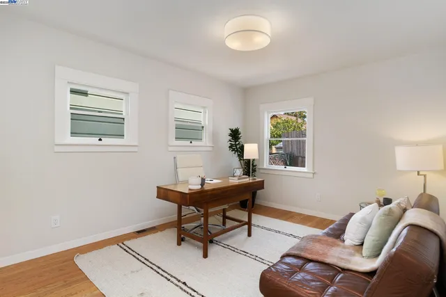a view of a workspace with furniture and a window