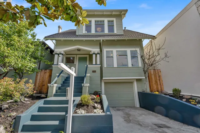 a front view of a house with wooden stairs and potted plants