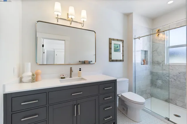 a bathroom with a toilet a sink a mirror and a shower