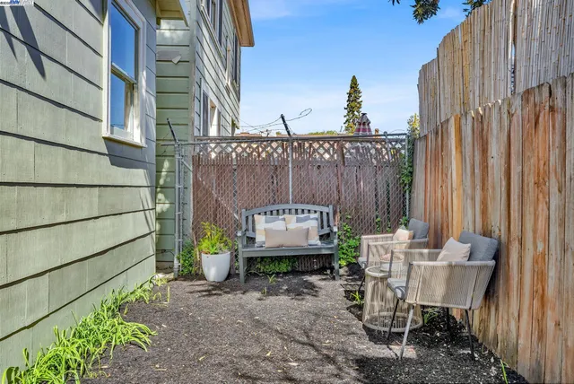 a view of a chairs and table in the back yard of the house
