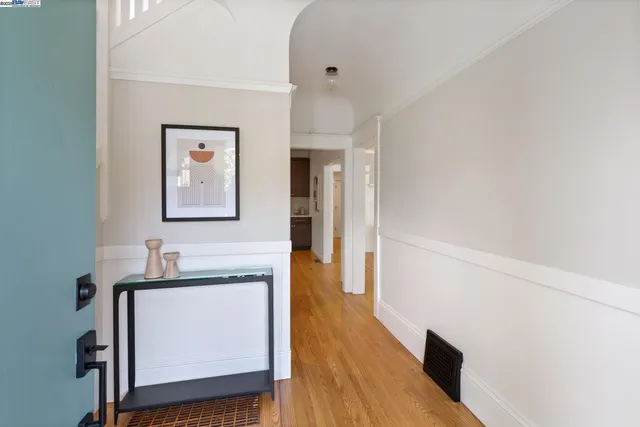 a hallway with wooden floor and a bathroom