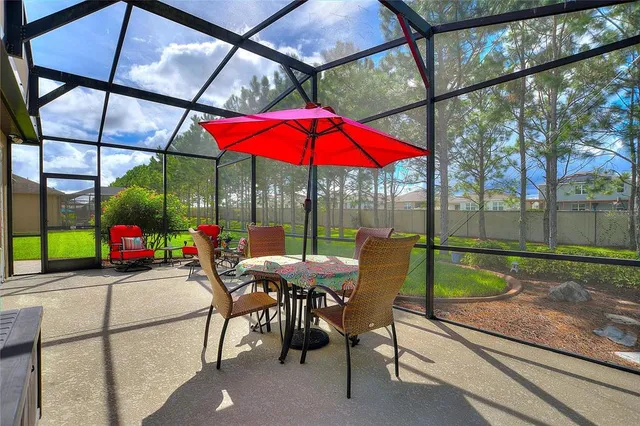 a view of a patio with a table and chairs under an umbrella